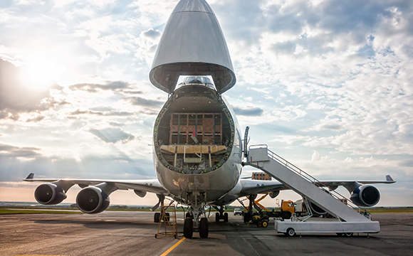 a plane being loaded with cargo to be transported internationally